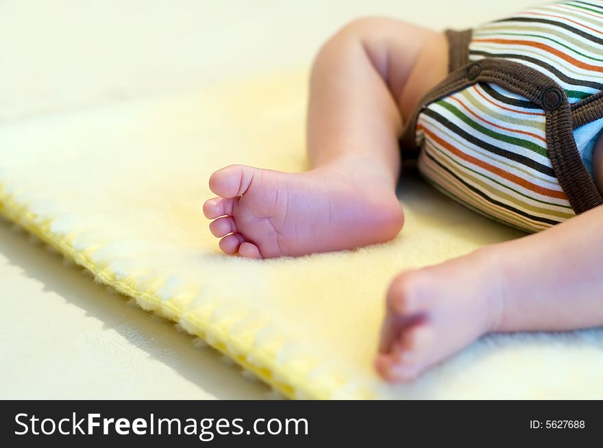 Newborn's legs on yellow blanket