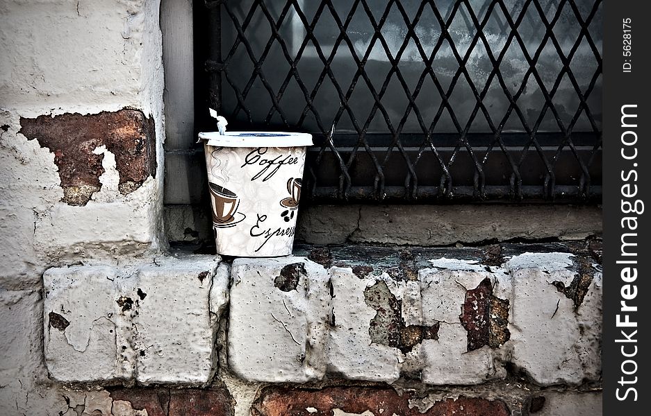 Closeup of discarded coffee cup on windowsill