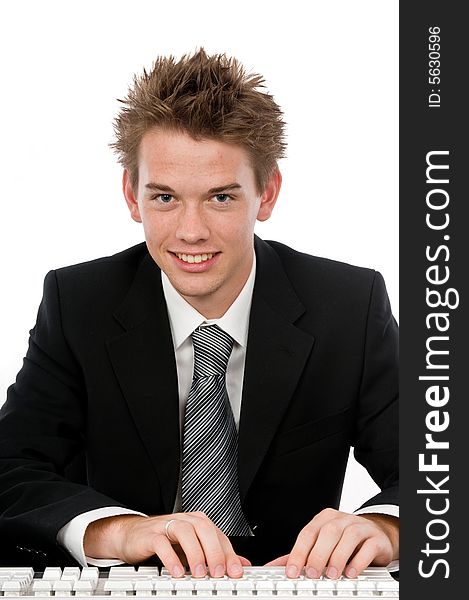 A handsome young businessman typing at his desk