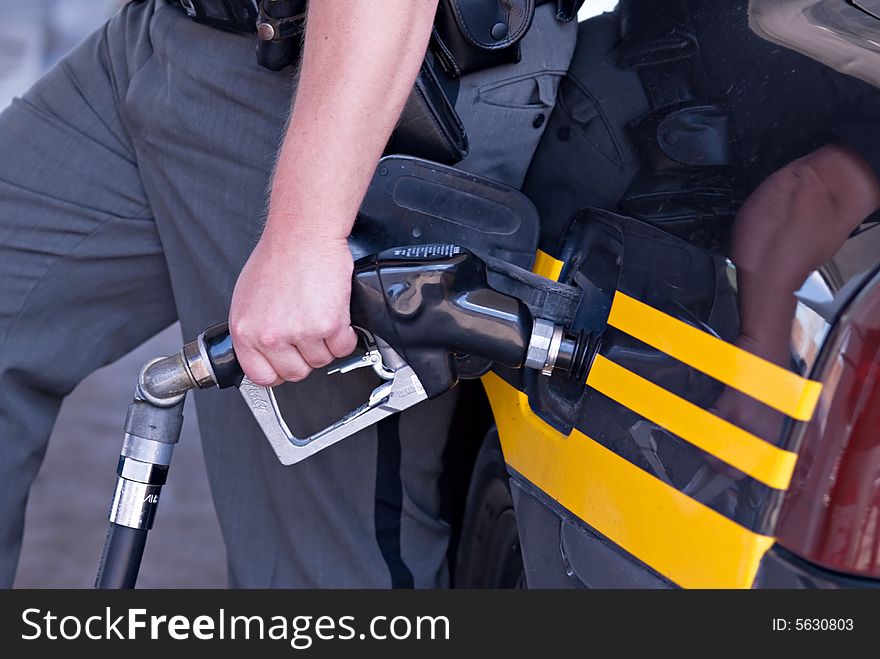 Close-up of Sheriff pumping gas.