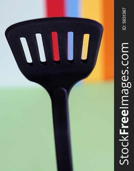 A big spoon with holes in a simple colorful background. A big spoon with holes in a simple colorful background