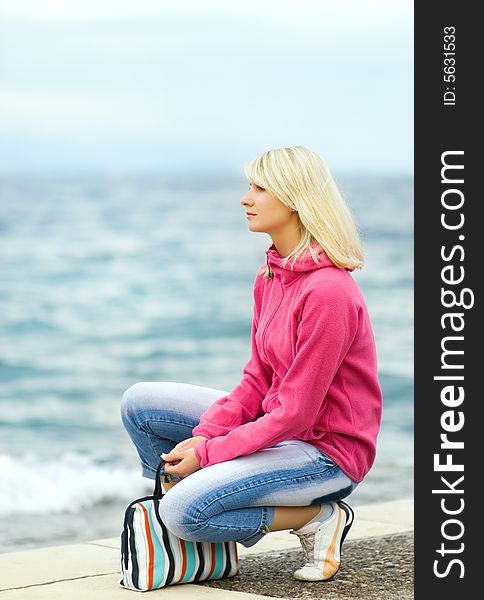 Picture of a Sad woman sitting near the ocean