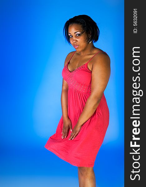 Young black woman in pink on blue background