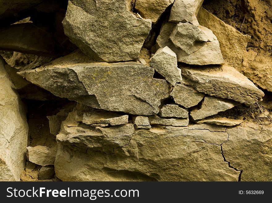 Old stone wall with the blasted laying