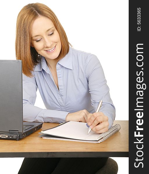 Young caucasian woman making note or writing on notepad, she is smiling. Young caucasian woman making note or writing on notepad, she is smiling