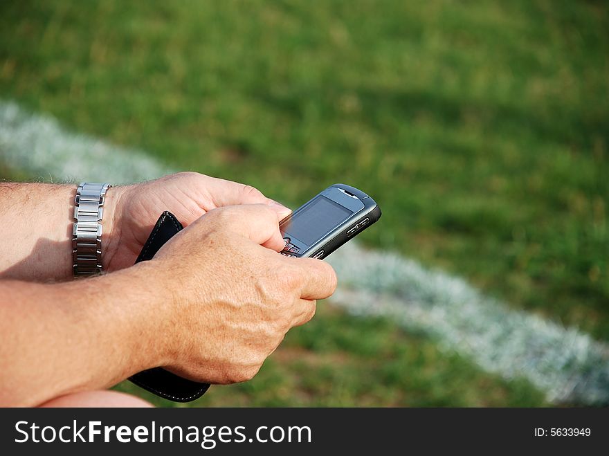 A business man sending e-mail during a soccer game. A business man sending e-mail during a soccer game.