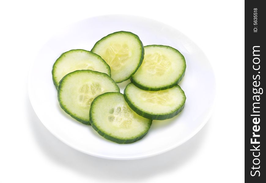 Fresh cucumber slices forming a circle on a white plate. Fresh cucumber slices forming a circle on a white plate