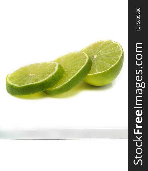 Sliced fresh lime on cutting board and isolated on white background
