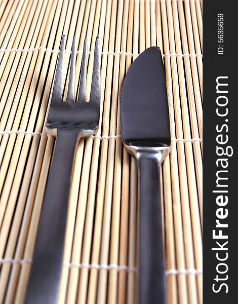 Fork and knife on bamboo wood