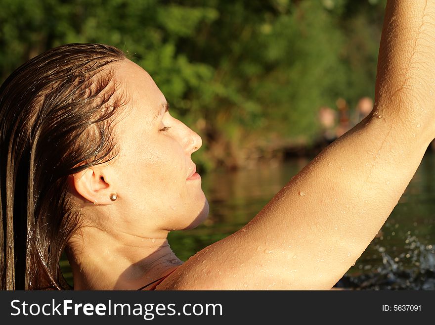 Woman with Wet Hairs in Water. Greens Background