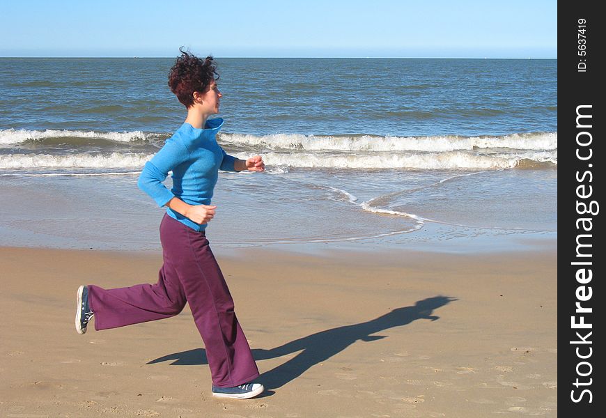She is doing exersice on the beach. She is doing exersice on the beach.