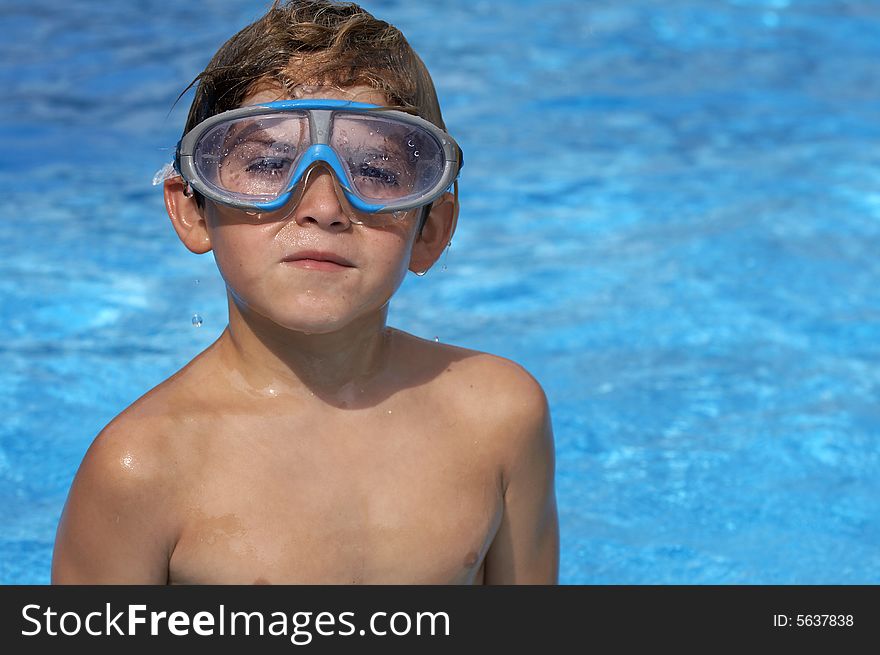 A young boy in pool with goggles on. A young boy in pool with goggles on