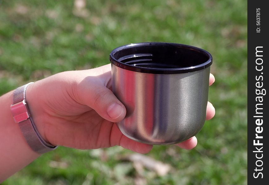 Cup in a hand during rest on walk on forest
