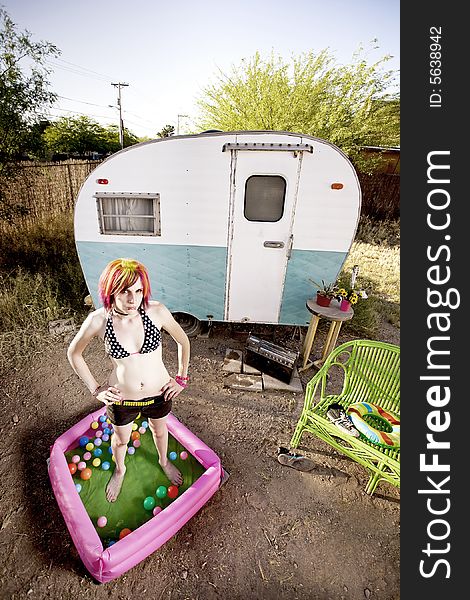 Woman standing in a play pool outside a trailer. Woman standing in a play pool outside a trailer