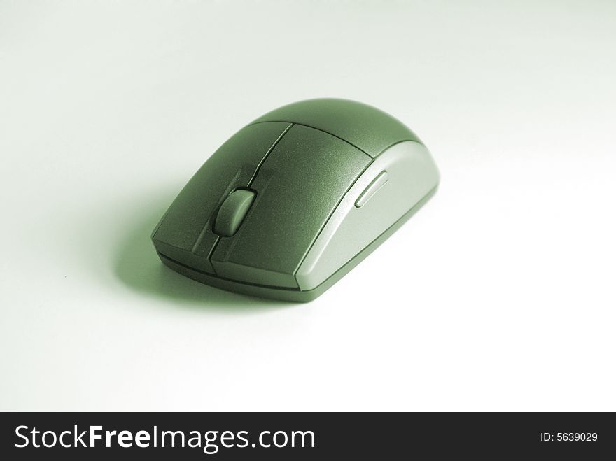 A wireless computer mouse on white with green color cast. A wireless computer mouse on white with green color cast.