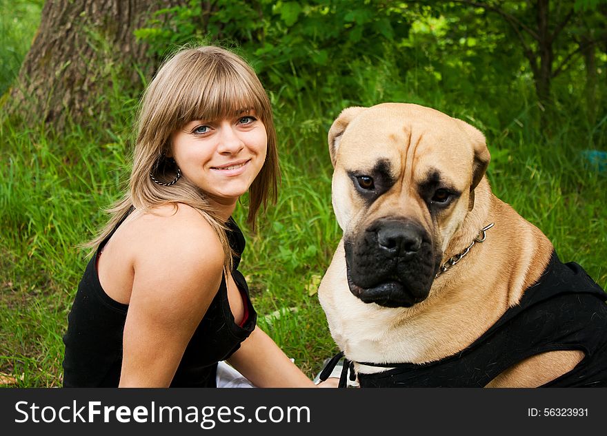 Beautiful young blond woman in a black shirt with her dog in the park. Beautiful young blond woman in a black shirt with her dog in the park