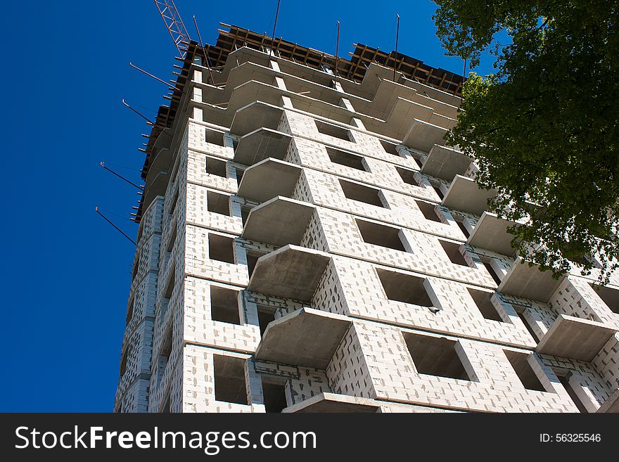 Construction of big apartment building on sunny summer day