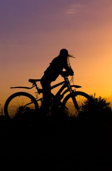 Silhouette Of A Gerl With A Bicycle Against The Sky At Sunset, Stock Photography Silhouette Of A Gerl With A Bicycle Against The Sky At Sunset, Stock Photography