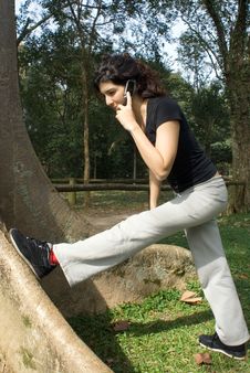 Woman Stretching Her Leg In Park - Vertical Stock Image