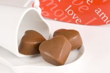 Three Heart Shaped Chocolates On A Cup And Saucer Stock Photos