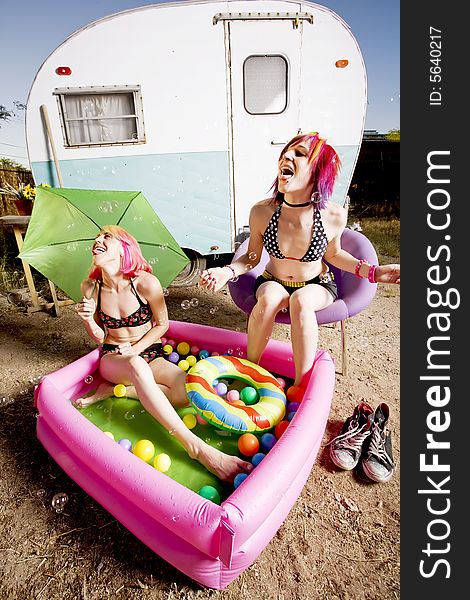 Woman with in an inflatable play pool playing with bubbles. Woman with in an inflatable play pool playing with bubbles