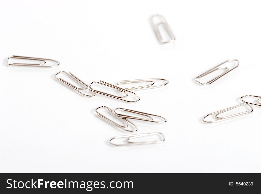 Paperclips spread on paper. Great for uses in office materials.