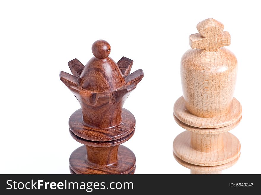 Two chess pieces standing beside each other. King and Queen close up of their crowns. Two chess pieces standing beside each other. King and Queen close up of their crowns.