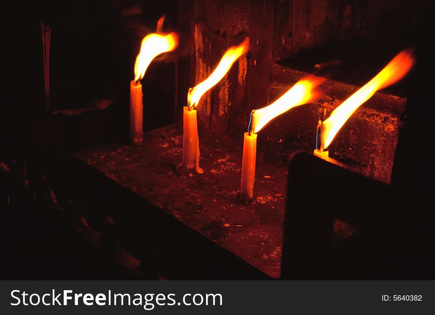 Blazing candle-flames in Buddhist temple in Chiang Mai, Thailand