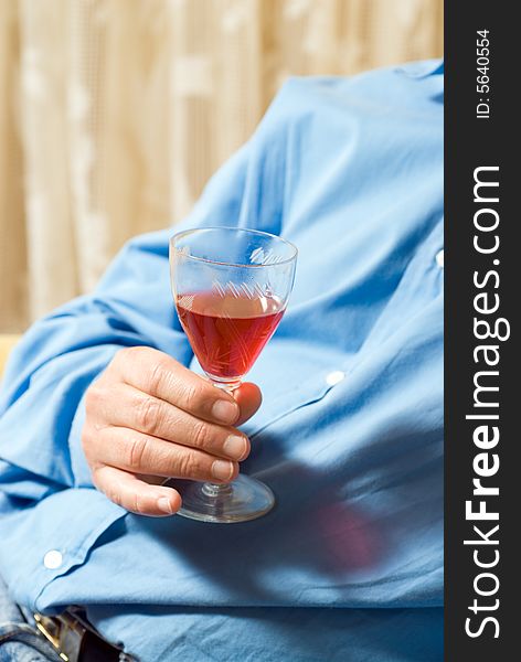 An abstract view of a man holding a wine glass. Vertically framed shot. An abstract view of a man holding a wine glass. Vertically framed shot.