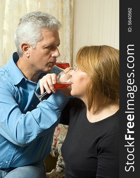 A couple drinking wine with interlocking arms.  Vertically framed shot. A couple drinking wine with interlocking arms.  Vertically framed shot.