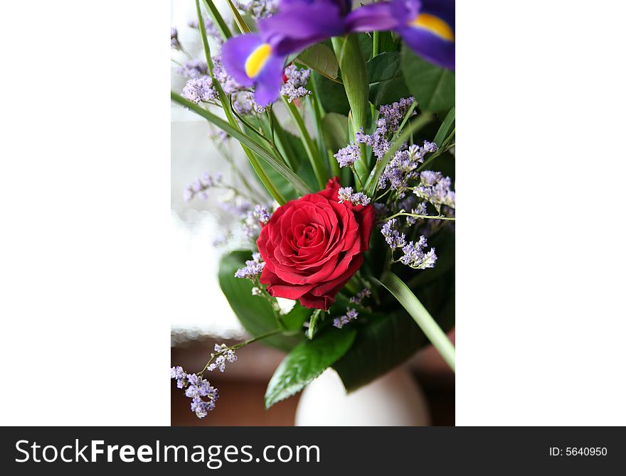 A bouquet with red roses and blue irises