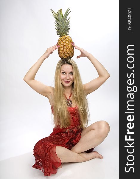 Sitting blonde long hair woman with a pineapple on her head. Sitting blonde long hair woman with a pineapple on her head