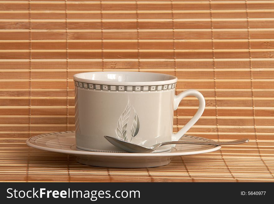 White cup of coffee on bamboo background