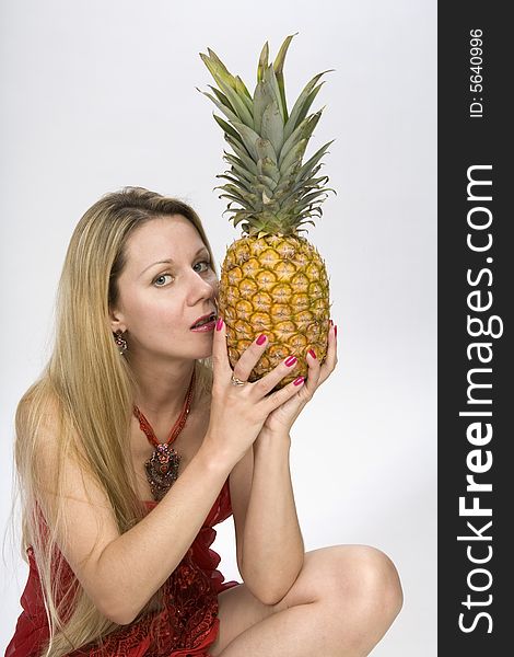 Blonde long hair woman with a pineapple in her hands. Blonde long hair woman with a pineapple in her hands