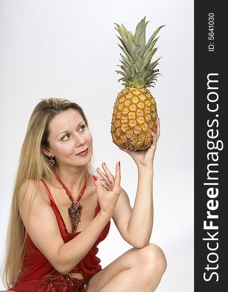 Blonde long hair woman with a pineapple in her hands. Blonde long hair woman with a pineapple in her hands