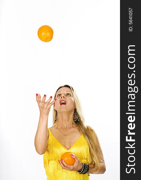 Blonde long hair woman trying to catch an orange. Blonde long hair woman trying to catch an orange