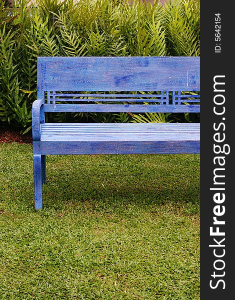 Bright blue painted wooden bench on green grass. Bright blue painted wooden bench on green grass.