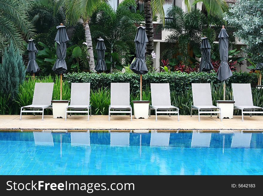 Beautiful swimming pool area with deck chairs.