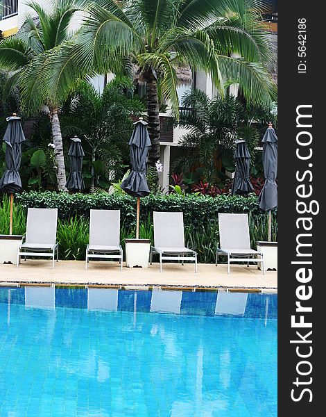 Beautiful swimming pool area with deck chairs. Beautiful swimming pool area with deck chairs.