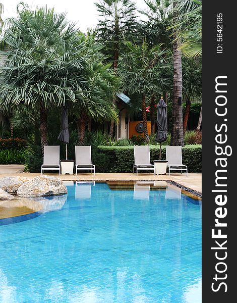 Beautiful swimming pool area with deck chairs. Beautiful swimming pool area with deck chairs.