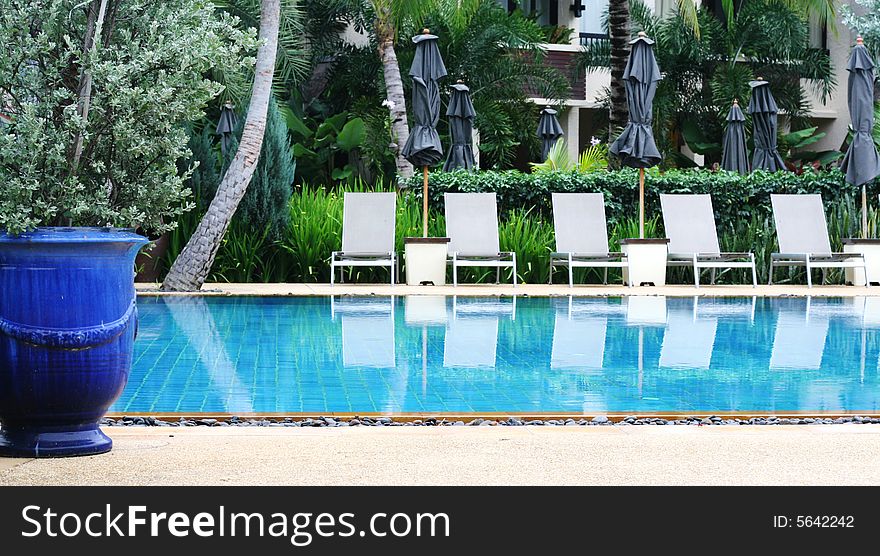 Beautiful swimming pool area with deck chairs.