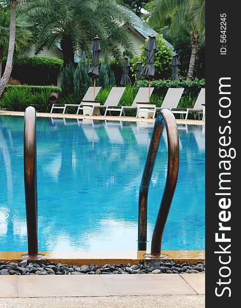 Beautiful swimming pool area with deck chairs.