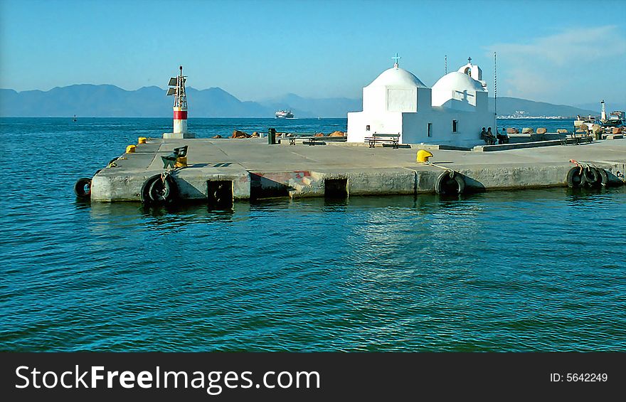 Small white greek church on the pier