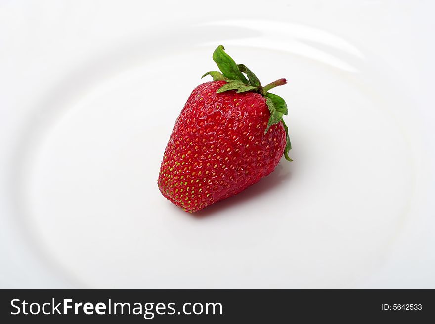 An appetizing strawberry on a white plate. An appetizing strawberry on a white plate