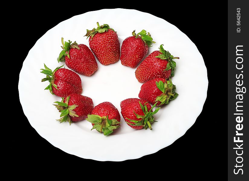 An appetizing strawberries on a white plate at the black background. An appetizing strawberries on a white plate at the black background