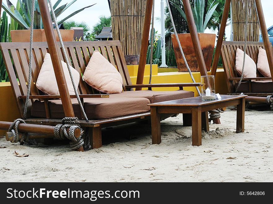Wooden table and chairs on sand at an outdoor restaurant. Wooden table and chairs on sand at an outdoor restaurant.