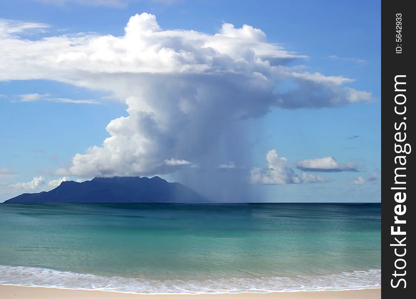 THis is the picture of beautiful clouds with rain over the sea and island on horizon. THis is the picture of beautiful clouds with rain over the sea and island on horizon.