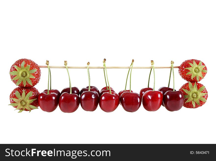 Strawberries and cherries suspended on a stick isolated on the white background. Strawberries and cherries suspended on a stick isolated on the white background