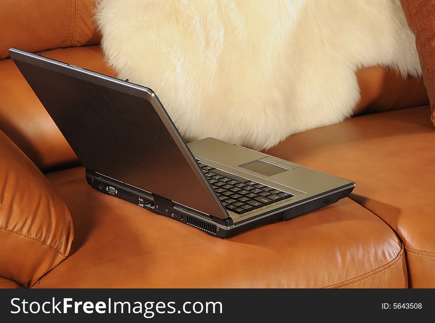 Close up pc on brown leather sofa. Close up pc on brown leather sofa