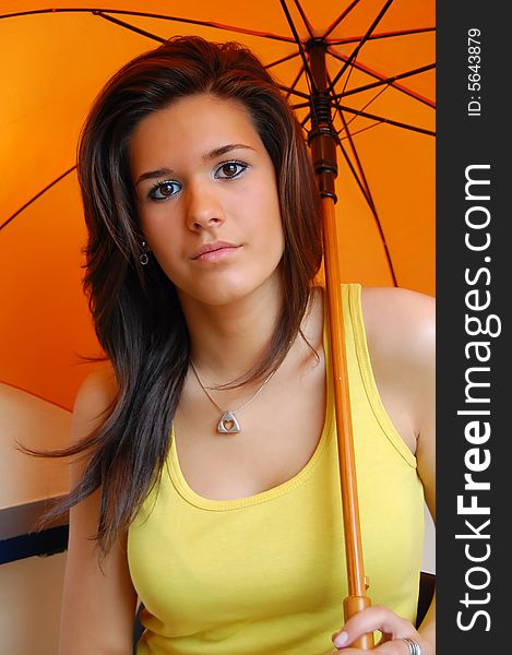 Portrait of a cute young girl with long hair, holding orange umbrella. Portrait of a cute young girl with long hair, holding orange umbrella